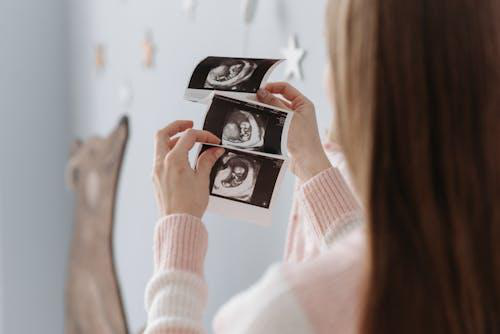 A woman holding her baby’s ultrasound prints