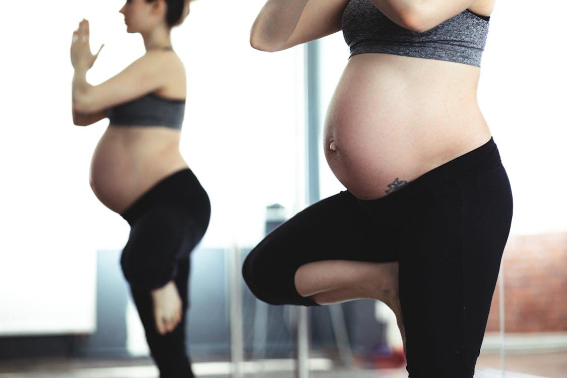 Cropped photo of a pregnant woman exercising